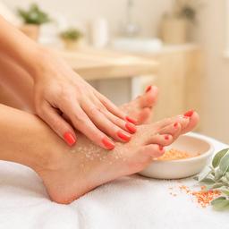Pedicure estetico con smalto corallo e scrub in una cabina luminosa della Toscana